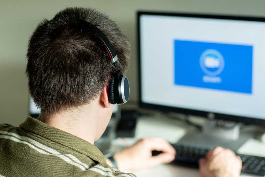 man-with-headphones-looking-on-the-monitor-with-zoom-cloud-meetings-logo-business-cloud-communication_t20_nLJY7O
