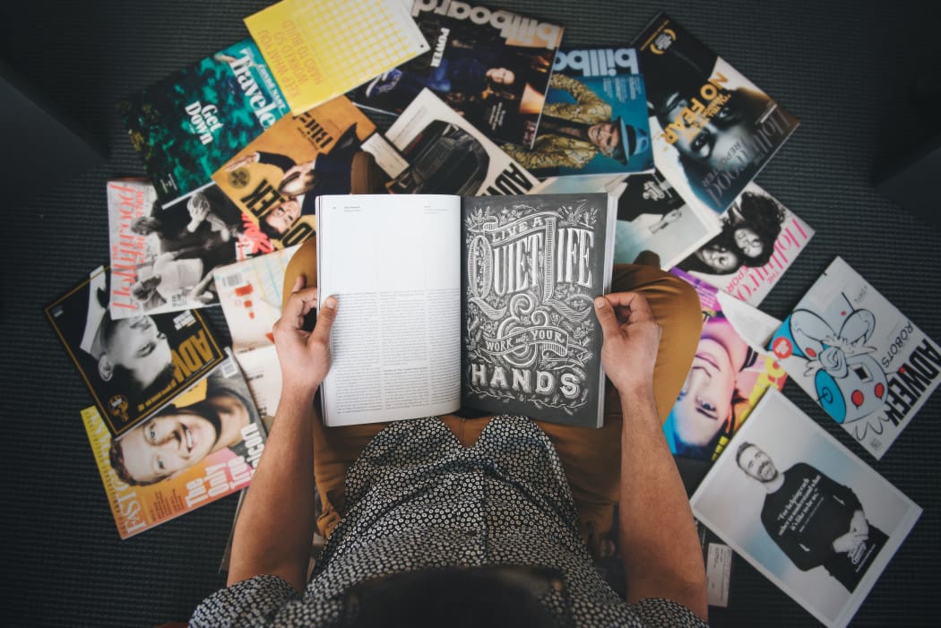 guy-reading-in-a-pile-of-magazines_t20_RwmBAw