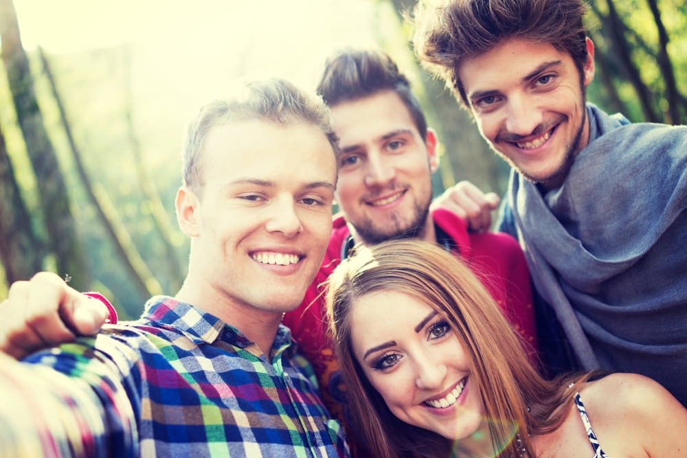 Young people having good time together in park on river and taking selfie-4